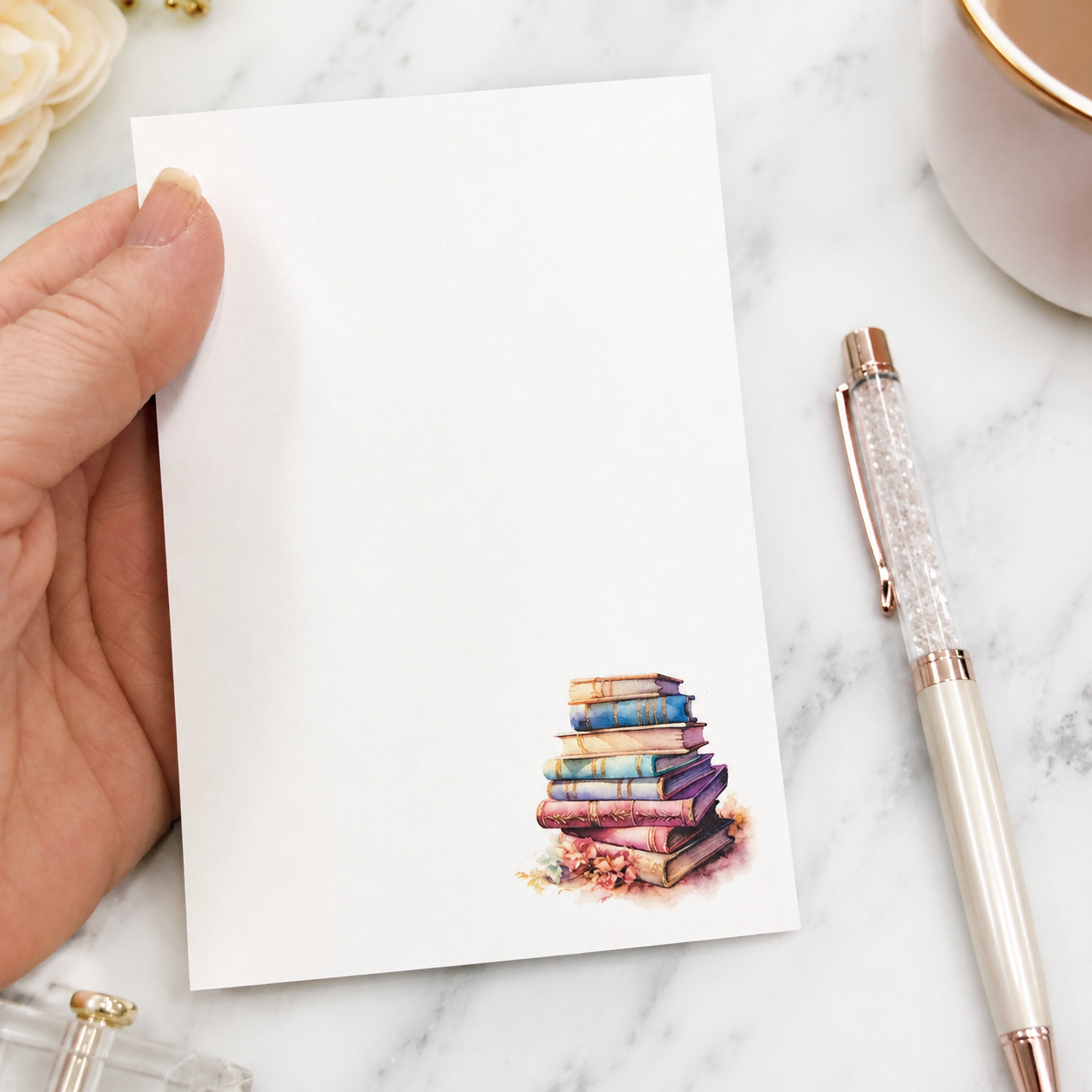 Book lover notepad featuring a watercolor stack of pastel vintage books in the corner with a clean writing area for notes, lists, and reminders.