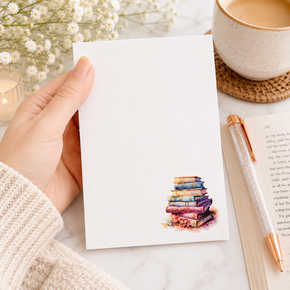 Book lover notepad featuring a watercolor stack of pastel vintage books in the corner with a clean writing area for notes, lists, and reminders.