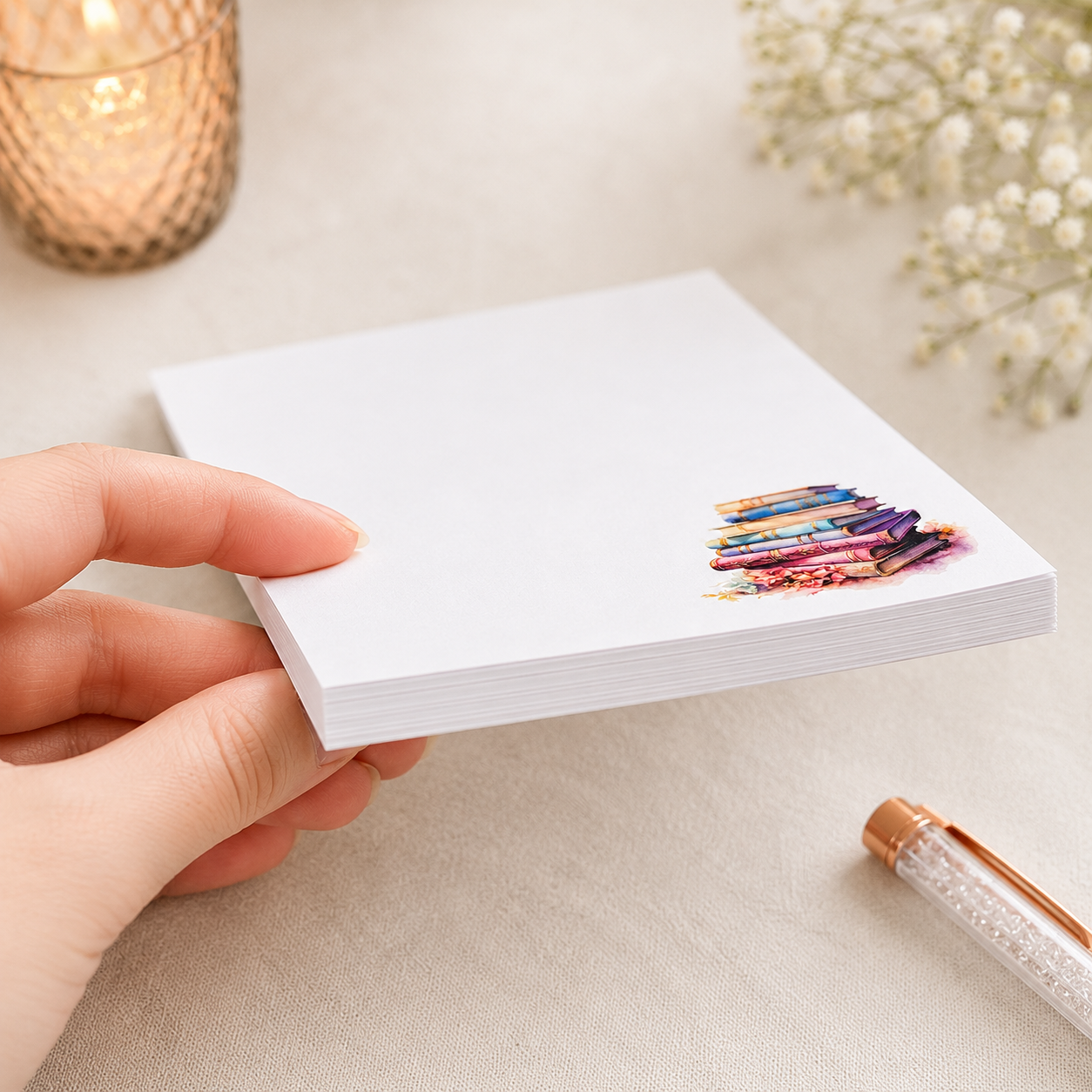 Book lover notepad featuring a watercolor stack of pastel vintage books in the corner with a clean writing area for notes, lists, and reminders.
