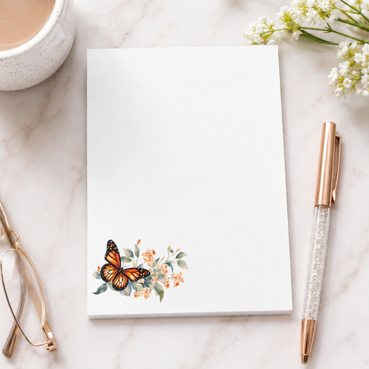 White butterfly floral notepad featuring a monarch butterfly with soft watercolor flowers in the corner and a large blank writing area.