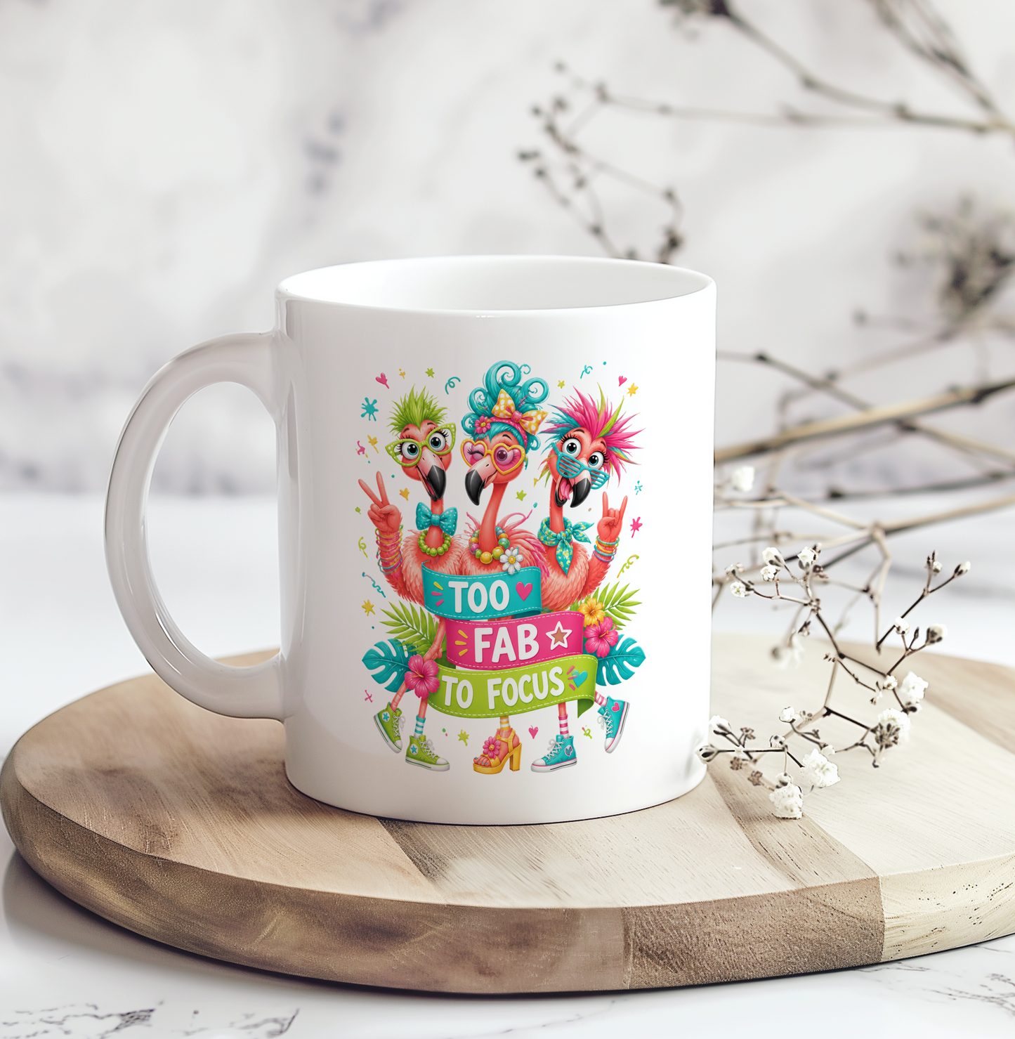 White ceramic coffee mug featuring three colorful flamingos wearing quirky accessories with the phrase "Too Fab to Focus," making it a funny flamingo mug, ADHD humor gift, and tropical coffee cup.