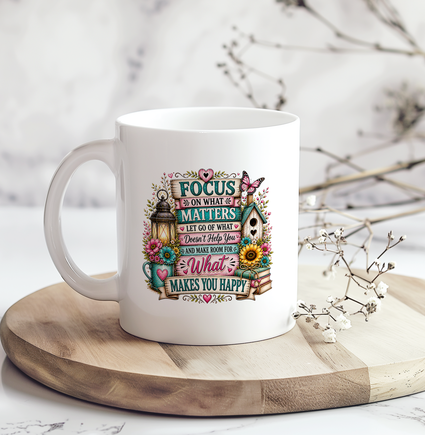 White ceramic inspirational coffee mug featuring the quote "Focus on What Matters" with colorful floral accents, books, a butterfly, lantern, and birdhouse, making a thoughtful motivational gift for women.