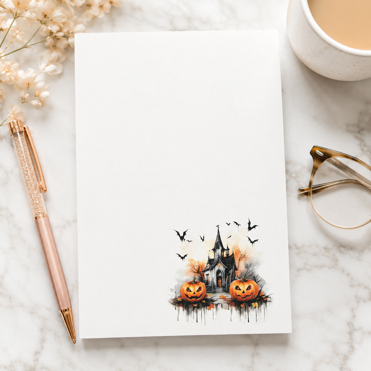 White Halloween notepad featuring a haunted house, smiling pumpkins, bats, and autumn accents in the lower corner.
