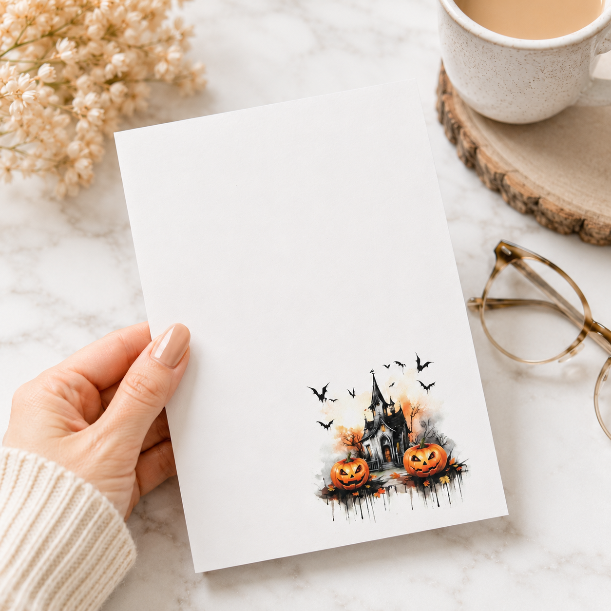 White Halloween notepad featuring a haunted house, smiling pumpkins, bats, and autumn accents in the lower corner.