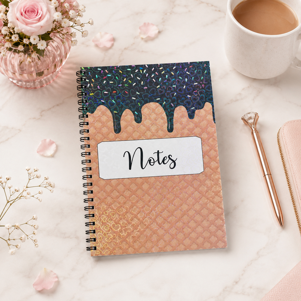 Peach and black holographic spiral notebook with lined pages, heart pattern cover, and Notes label displayed in a bright feminine workspace setting.