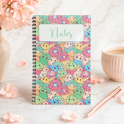 Pastel kawaii dessert spiral notebook featuring cute donuts, cupcakes, ice cream treats, and smiling sweets on a colorful glossy cover.